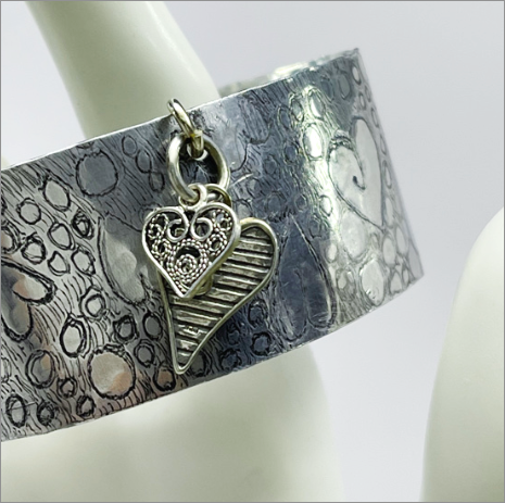 Hand-etched aluminum cuff bracelets created by jewelry artist, Dee Van Houten